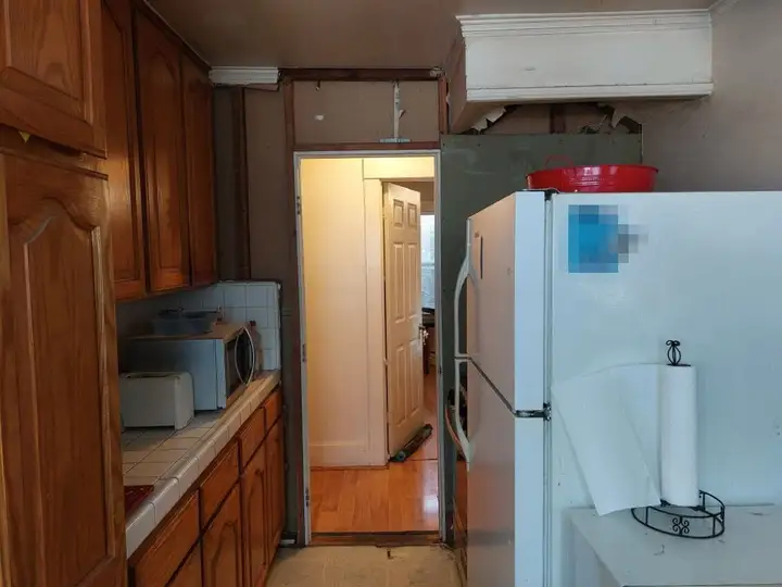 The kitchen looking through to the hall, the wall above the door opened up