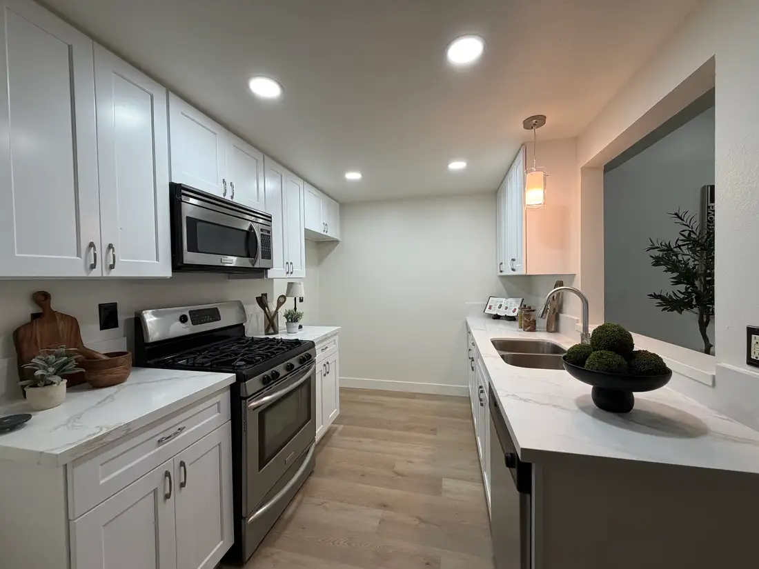 The same kitchen finished for market: white shaker cabinets, stone counters and new flooring